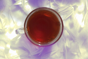 Flat lay with cup of tea  with copy space, Blurred background, Sunset light and shadows. At home.