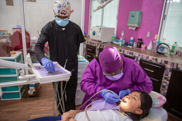 Dentista mexicana, chequeo médico de la cavidad bucal de la paciente con instrumentos dentales
