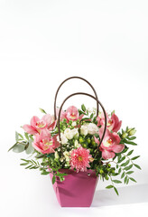 delicate orchids in a gift box or basket on a light background. bouquet of orchids, roses and chrysanthemums.