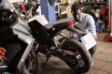 Mechanic is repairing modern moto in the workshop. High quality photo