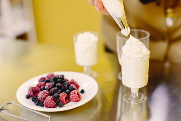 Confectioner works with a pastry bag