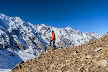 Naklejka premium Beautiful landscape with mountains, blue huge glacier and a middle-aged mountaineer man against the background of mountains, glacier