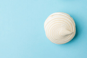 Fototapeta na wymiar Fresh meringue with vanilla on a blue background. Flat lay.