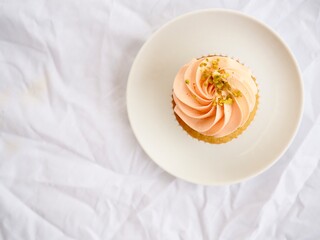 Pretty pink cupcake with white space minimally styled on a white background