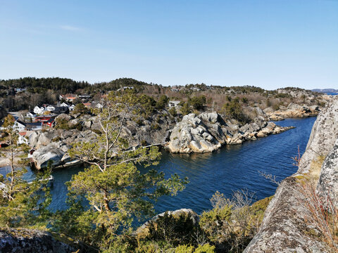 Beautiful shot of a rocky shore and trees in Kjerringvik, Norway