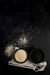 Black and white sesame seed on black background. Organic food concept