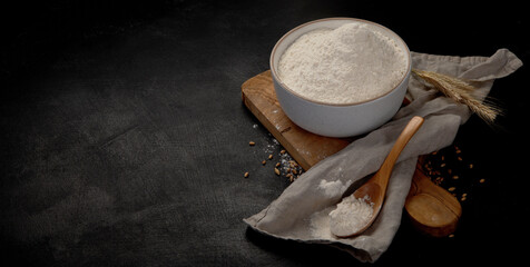 Wheat flour on dark background. Food preparing concept.