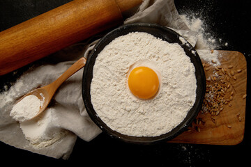 Wheat flour on dark background. Food preparing concept.