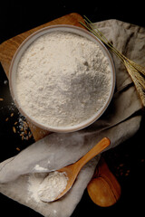 Wheat flour on dark background. Food preparing concept.