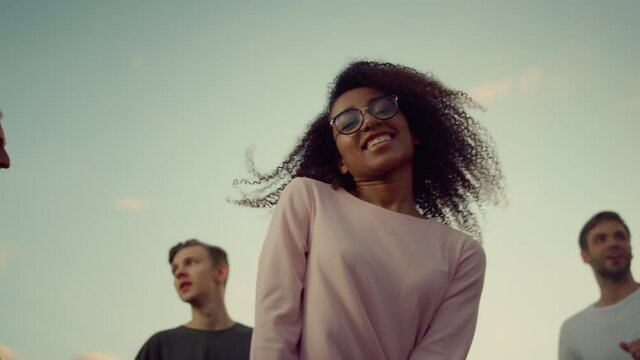 Smiling african girl dancing at disco. Multiethnic people having fun at party