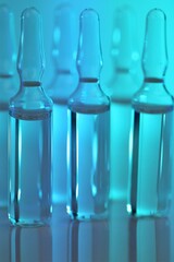  Ampoules with solution for injection. Medicine and
 Pharmacology.Biotechnology and Science.Glass transparent ampoules set on a blue  background.Health and beauty.Organic natural cosmetics