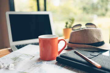 coffee cup and other travel accessories around on the table. Vocation, travel, holidays and backpack concept.