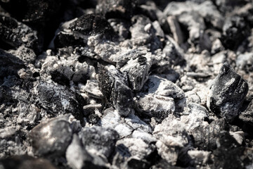 Black burnt coals in the grill close-up.