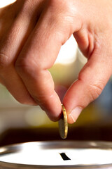A female hand about to introduce a coin in a money box. Save money concept banner.