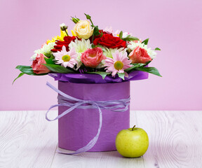 Bouquet of wildflowers and apple on wooden boards.