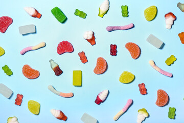 Different jelly candies on color background