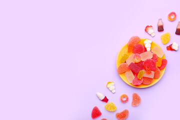 Plate with sweet jelly candies on color background