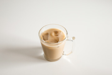 Ice coffee with milk on a white wood table and refreshing look of the drink, with a clean white background.