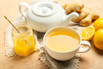 Teapot and cup of tea with ginger on color background