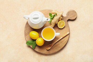 Teapot and cup of tea with ginger on color background