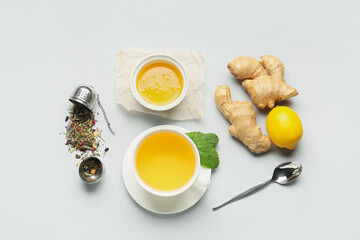 Cup of tea with ginger, honey and lemon on light background