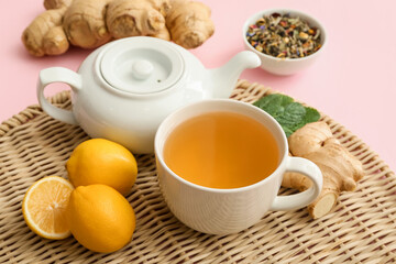 Teapot and cup of hot tea with ginger on color background