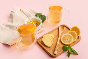 Cups of tea with ginger, honey and lemon on color background