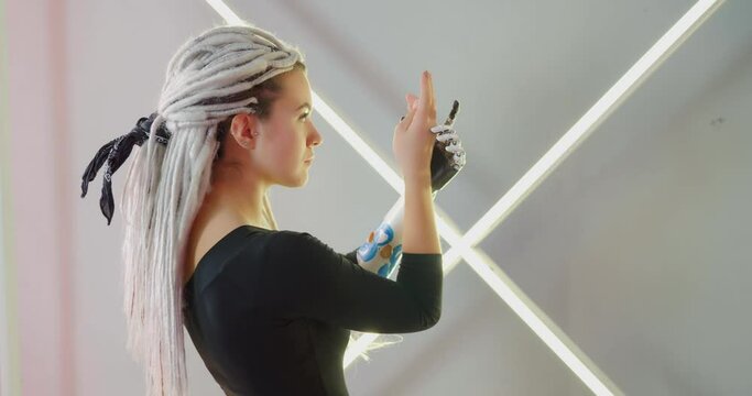 The woman with the robotic arm is posing with neon background Bionics Cybernetic Robotic-arm Hand prosthesis