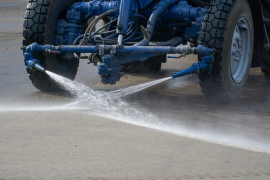Washing asphalt and streets with water jets from special cleaning equipment.