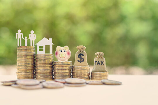 Money Saving, First Time Asset / Property Buyer Concept : Family Couple, Home Model, Piggy Bank, Dollar And Tax Bags On Stacks Of Rising Coins, Depict Budget Planning For Basic Needs, Personal Expense