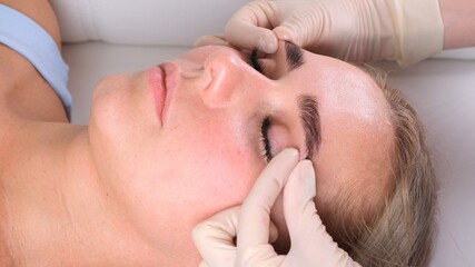 Fototapeta na wymiar Beautiful woman in salon having facial massage.