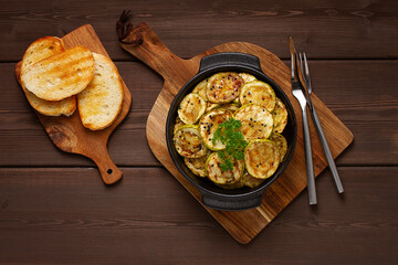 Grilled zucchini, with spices, top view, on a wooden brown table, horizontal, no people,