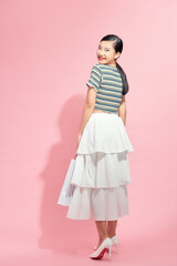 Portrait beautiful young asian woman with white shopping bag on pink isolated background