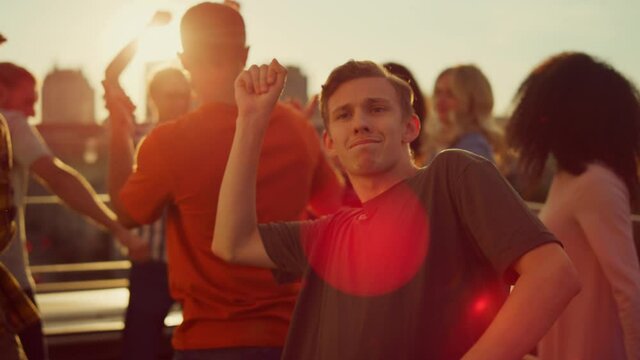 Energetic guy dancing at urban party. Multiracial people partying outdoors.