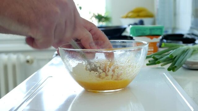 Mixing Eggs in a Bowl for an Omelet, a Delicious Homemade Breakfast 