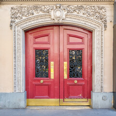 Paris, an ancient red wooden door, typical building in the center
