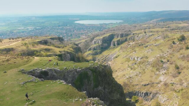 Scenic aerial drone shot of Cheddar Gorge, reservoir and town in Mendip Hills, UK