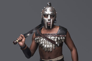 Violent gladiator with sword against gray background