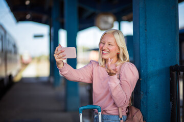   Woman waiting on train station using smart phone.