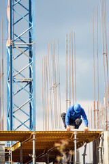 Real construction worker working on a high building and leveling floor for cementing.