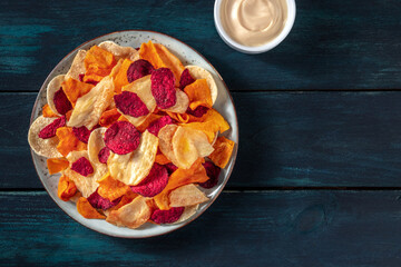 Colorful vegetable chips with a homemade dip, overhead shot