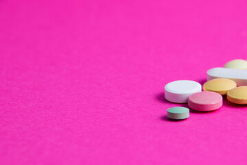 Pills on pink paper background with copy space. Covid 19 treatment concept