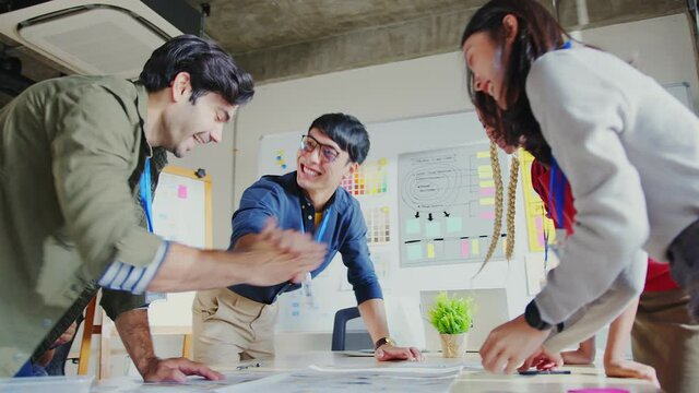 Meeting of UX developer and UI designer brainstorming about mobile app interface workflow design on a table with coworker brief and color code at co-working space.Creative digital development agency.