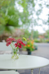 Bouquet of flowers in a decorative pot on the table empty cafe, Filled color filter.
