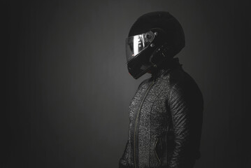 Motorbiker is looking aside on a dark background with a copy space. Side view.