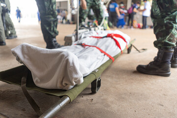 Military medical staff practicing transporting patients using stretchers.