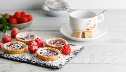 Cookie with raspberry glazing. Homemade biscuit, cookie with raspberry jam on top , on a cutting board with sugar powder glazing. Posed on a white background.