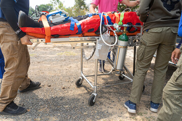 The nurse is moving the patient on the stretcher.