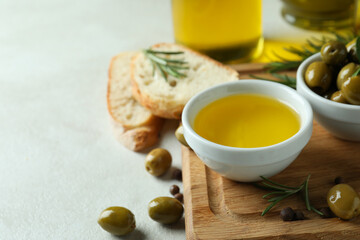 Concept of tasty eating with olive oil on white textured background