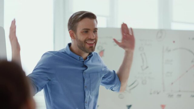 Happy man celebrating success colleagues office. Leader making presentation